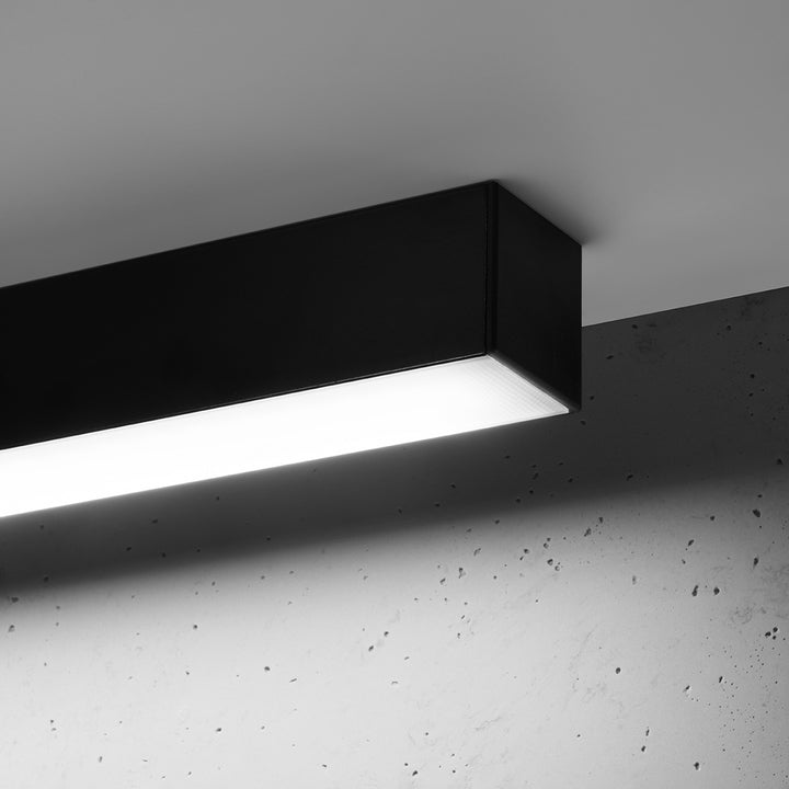 Plafonnier linéaire PINNE noir allumée, détail du diffuseur opale