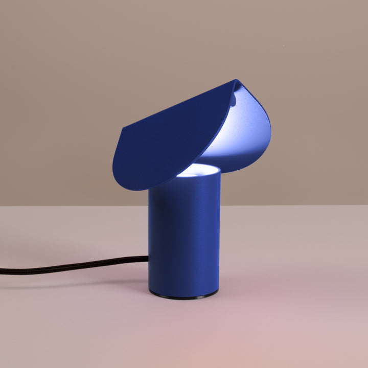 Lampe à poser BISCUIT outremer allumée, sur une table
