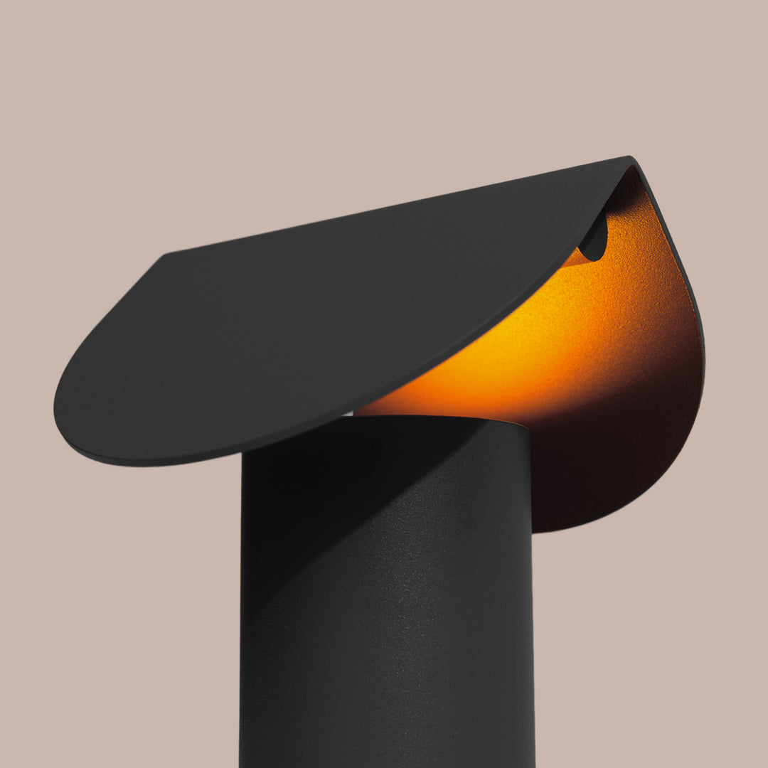 Lampe à poser BISCUIT noir allumée, vue de trois quarts