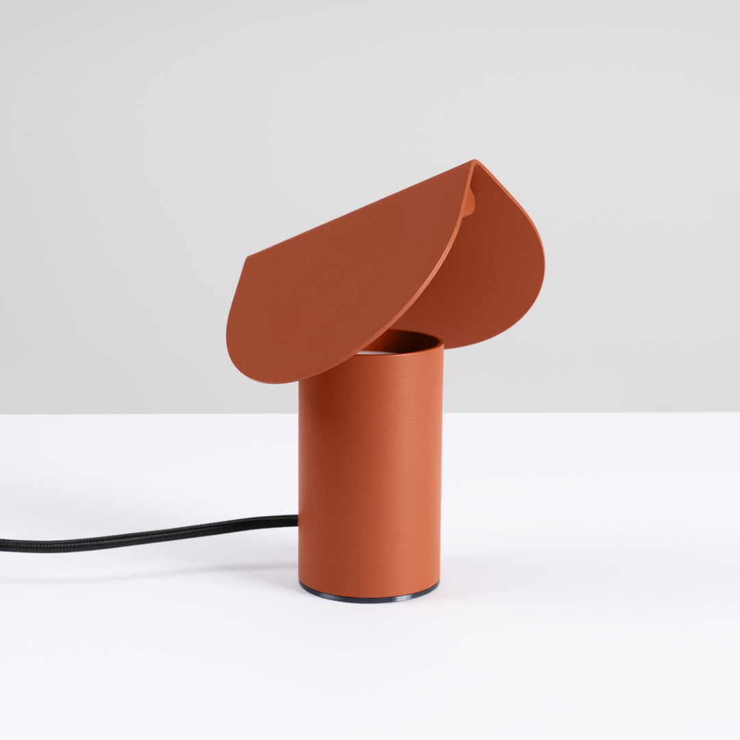 Lampe à poser BISCUIT ocre rouge éteinte, sur une table