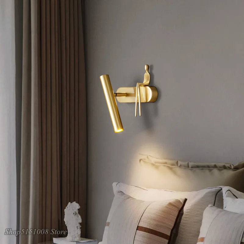 Applique murale LED noir avec un bonhomme doré assis

