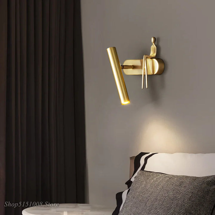 Applique murale LED noir avec un bonhomme doré assis


