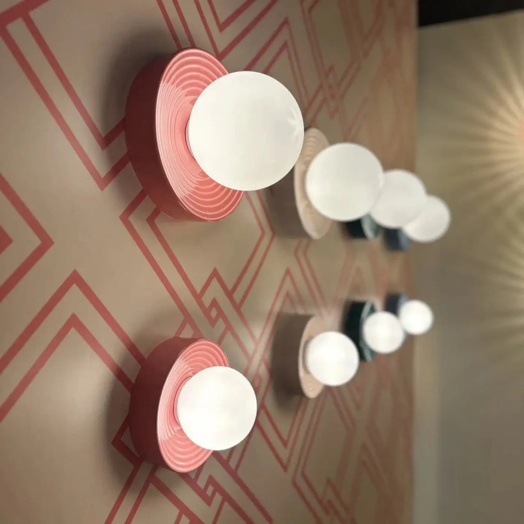 Applique murale alicia en sphère rose et blanche avec motifs circulaires concentriques sur la base