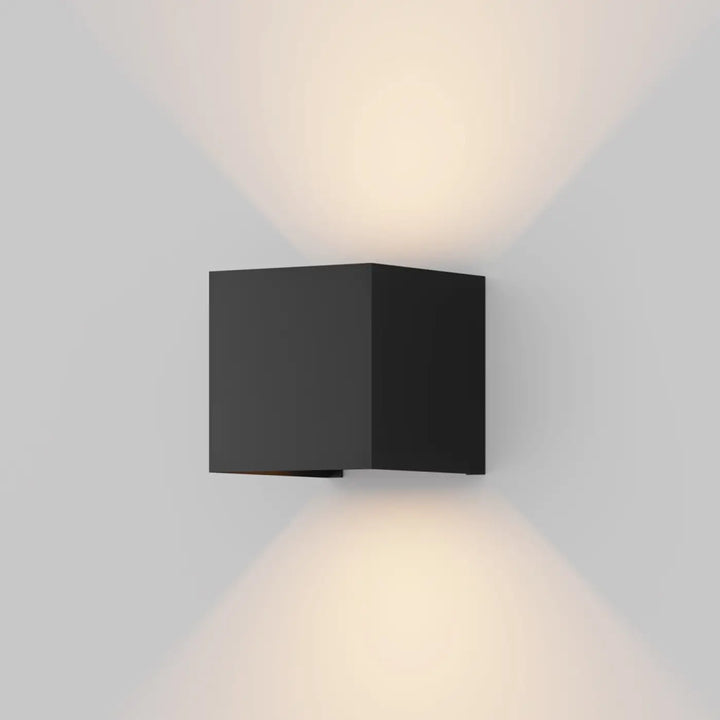 Applique extérieure fulton cube noir mat avec double faisceau et design angulaire émettant une lumière chaude directionnelle