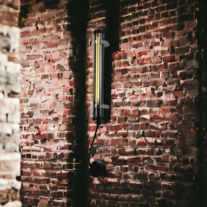 Applique lukas noire cylindrique murale avec bandes led verticales émettant une lumière jaune chaude pour luminaire extérieur