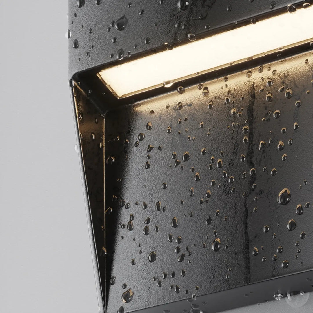 Applique extérieure noire en texture avec balise carrée et led intégrée diffusant une lumière douce et moderne