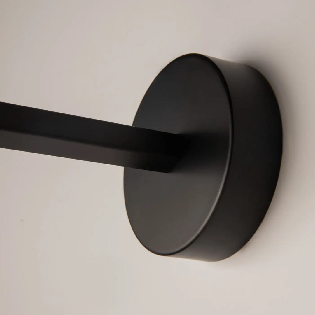 Applique murale long bras en métal noir avec tête ronde et finition mate pour éclairage mural moderne