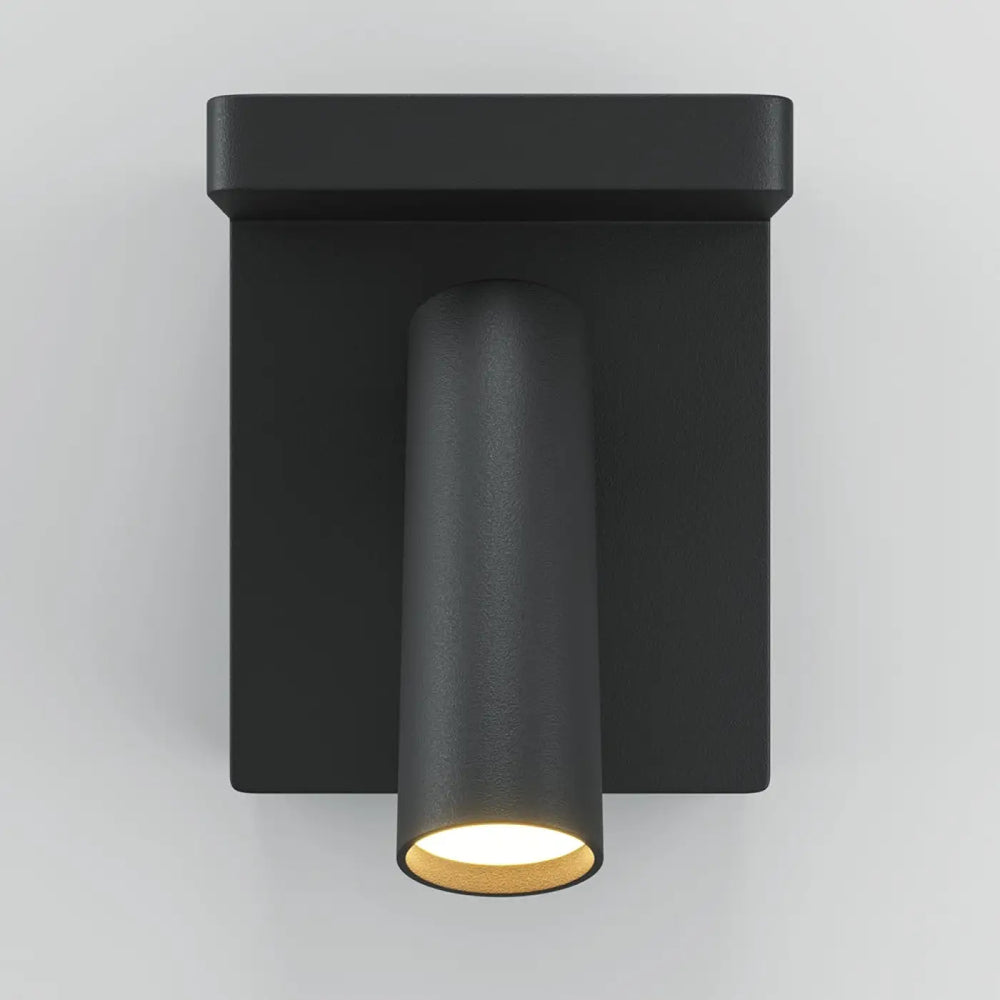 Applique murale aron noire avec spot led orientable cylindrique émettant une lumière chaude pour espace intérieur