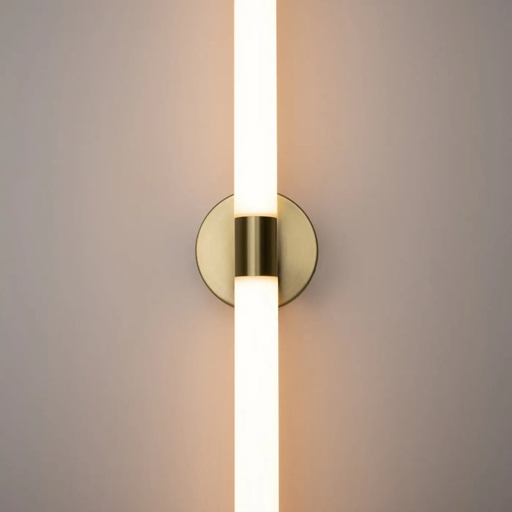 Applique murale axis en acrylique blanc mat avec tube led vertical au fini laiton moderne diffusant une lumière blanc chaud