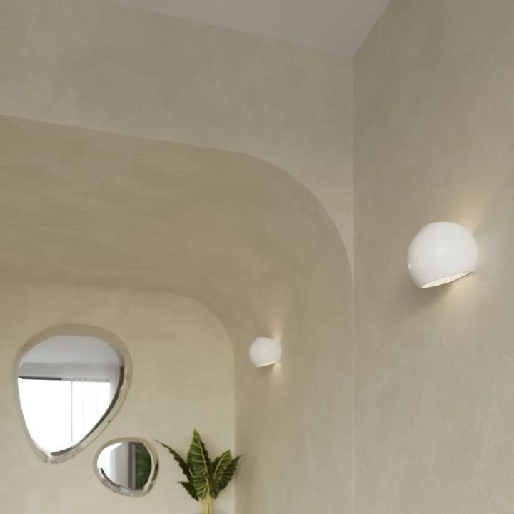 Deux appliques murales modernes en céramique globe blanc brillant avec finition laquée sur mur beige