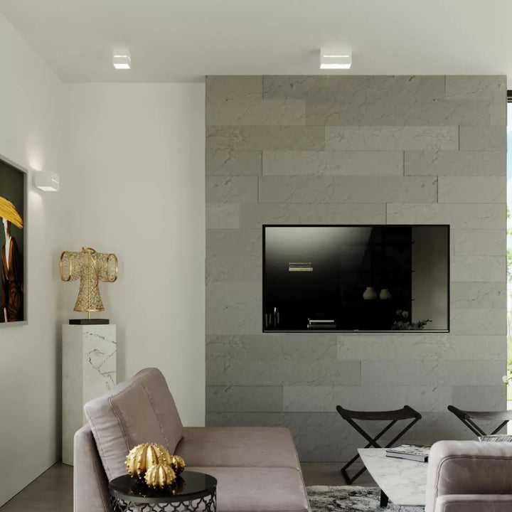 Applique murale lobo blanc avec perforation linéaire moderne montée sur un mur en marbre gris avec télévision écran plat noire
