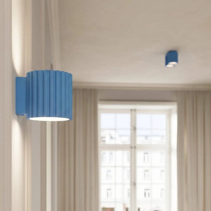 Applique murale bleu clair allumée, vue rapprochée