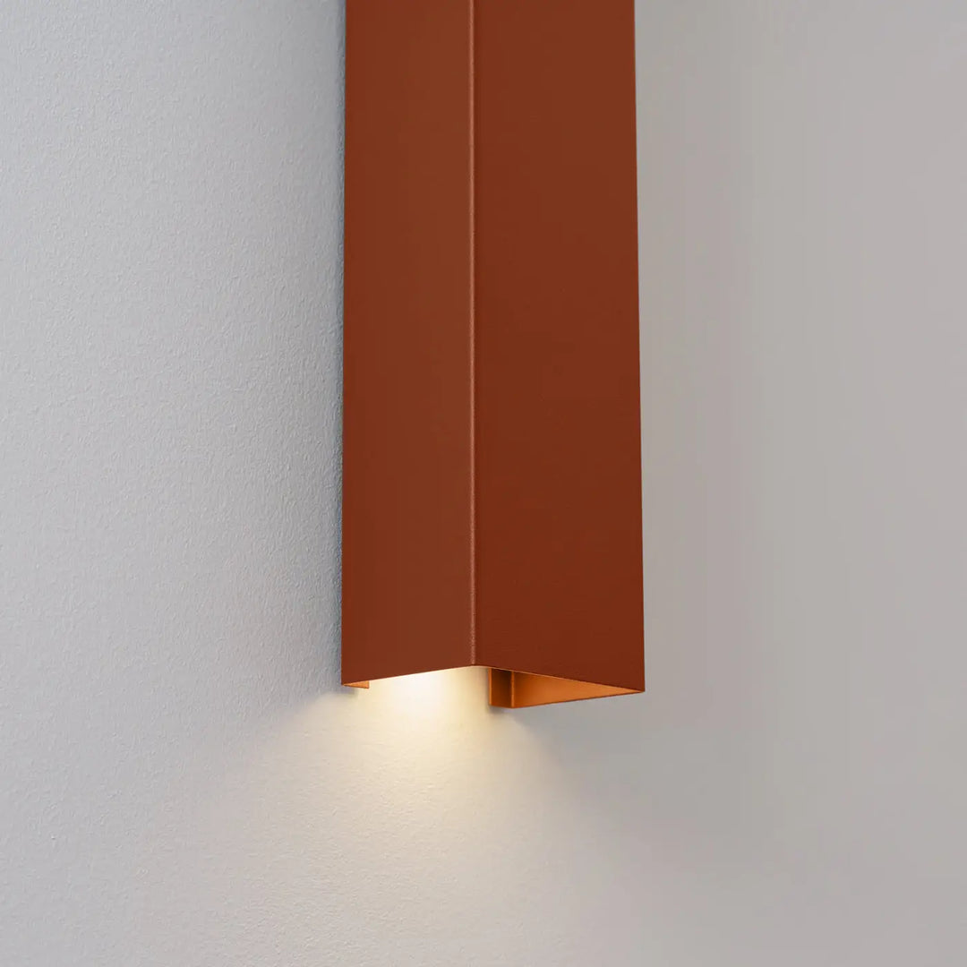 Applique murale FREYA ocre rouge allumée, détail de la sortie de lumière