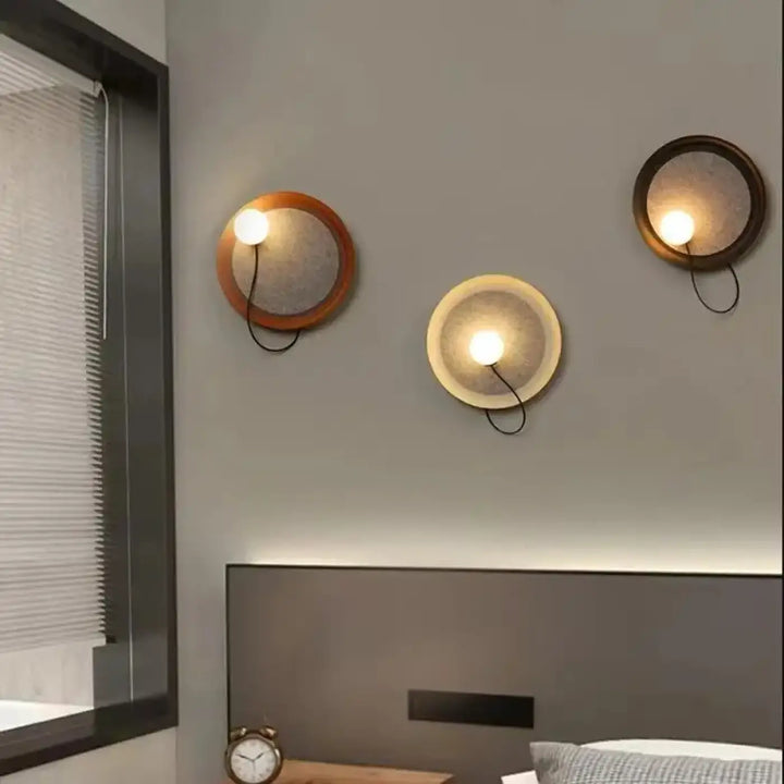 Trois appliques murales contemporaine avec abat-jours texturés tons chauds et cadres en bois ou métal par Orluna