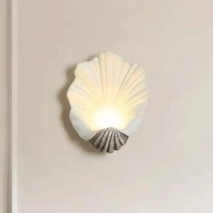 Applique murale TIAUIA coquillage off-white avec base grise texturée éclaire chaleureusement