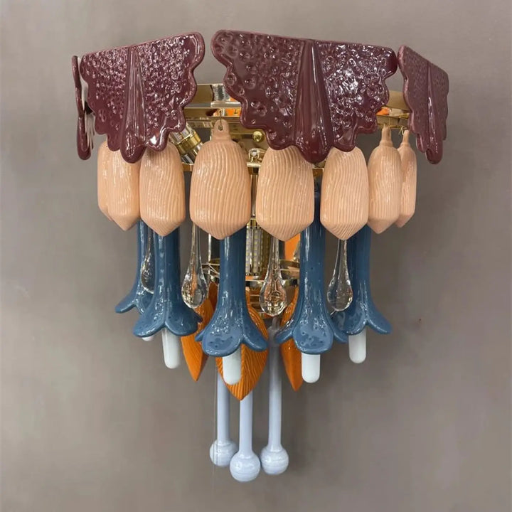 Applique murale design avec dessus en céramique bordeaux texturée et pampilles colorées en verre pêche et fleurs en porcelaine bleue