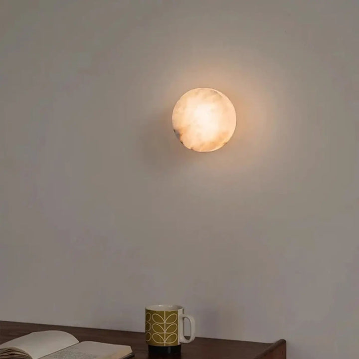 Applique murale laurel avec lumière décorative chaude, forme circulaire et texture naturelle pierreuse