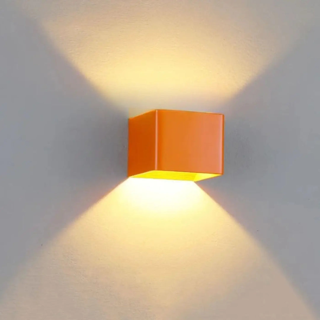 Applique murale tesser orange en forme de cube avec lumière jaune chaude émanant de lintérieur