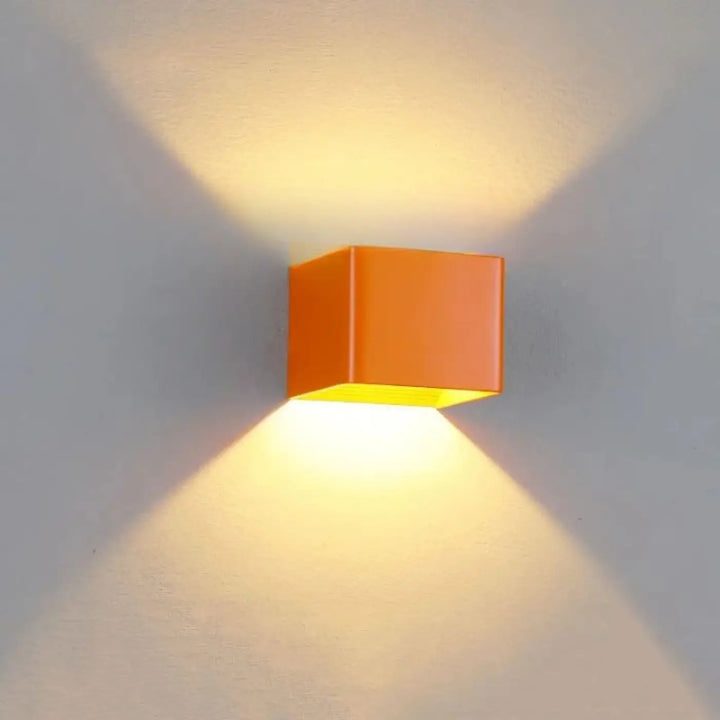 Applique murale tesser orange en forme de cube avec lumière jaune chaude émanant de lintérieur