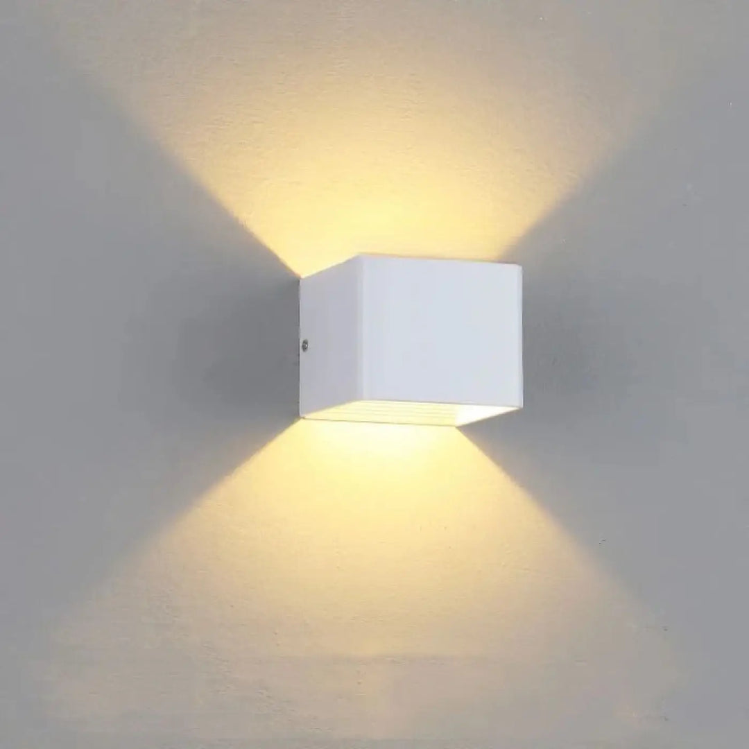 Applique murale tesser cube blanc au design moderne minimaliste émettant une lumière jaune chaleureuse
