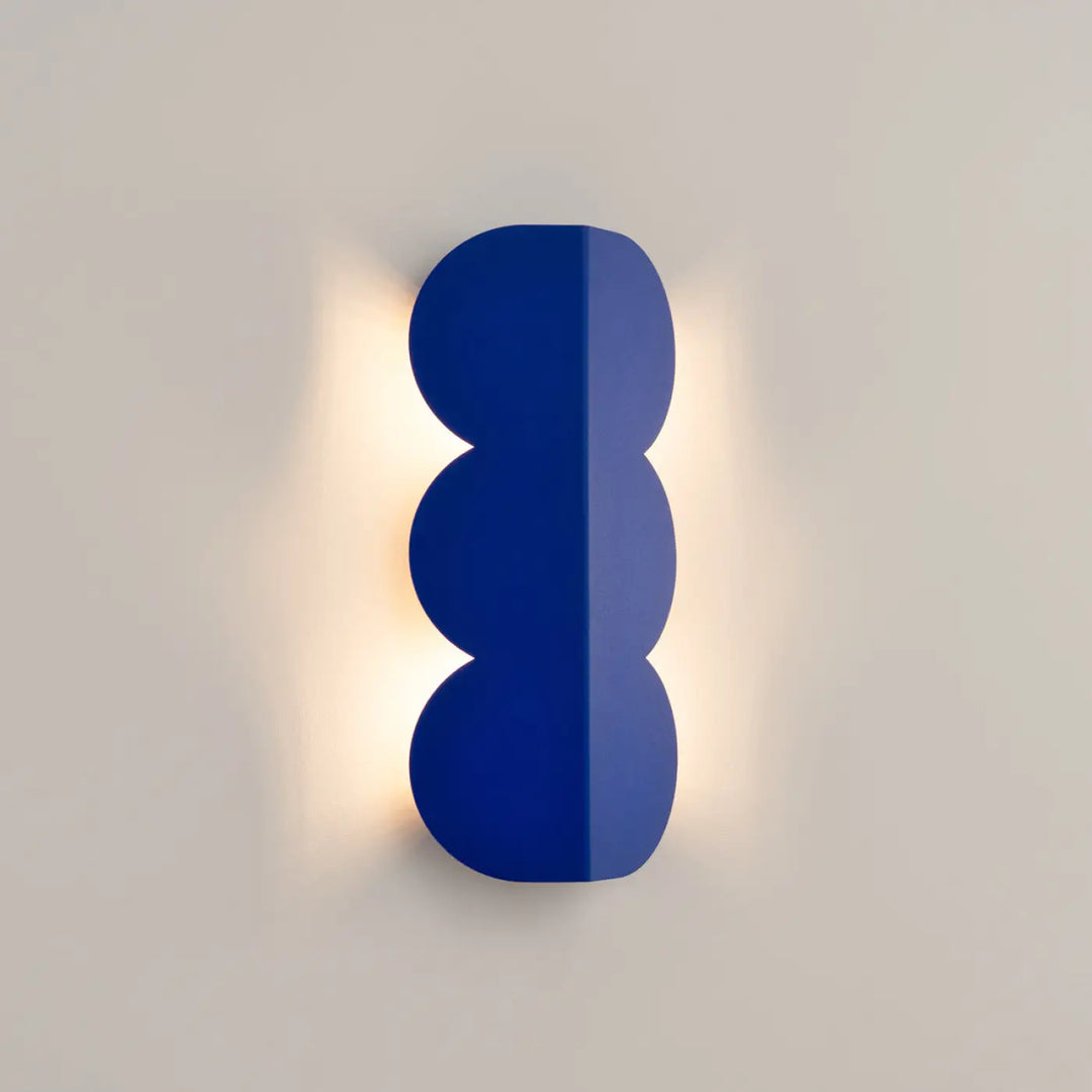 Applique murale biscuit outremer compose d’une lampe à forme ondulée caractéristique en finition bleu cobalt lumineux