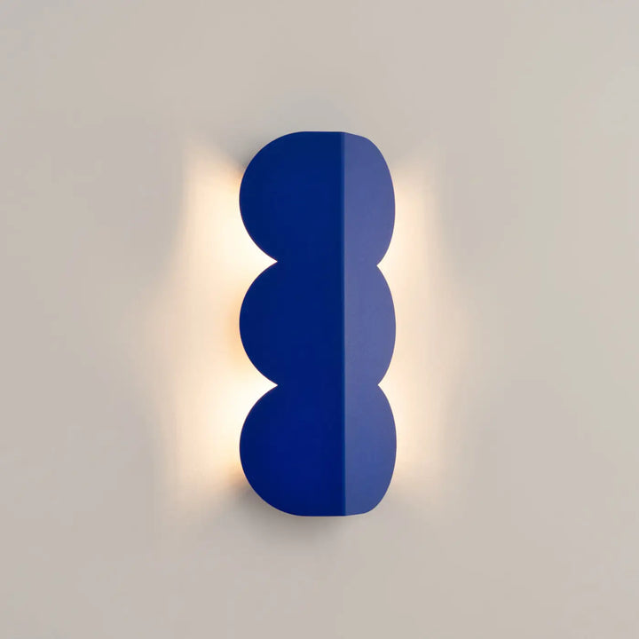 Applique murale biscuit outremer compose d’une lampe à forme ondulée caractéristique en finition bleu cobalt lumineux
