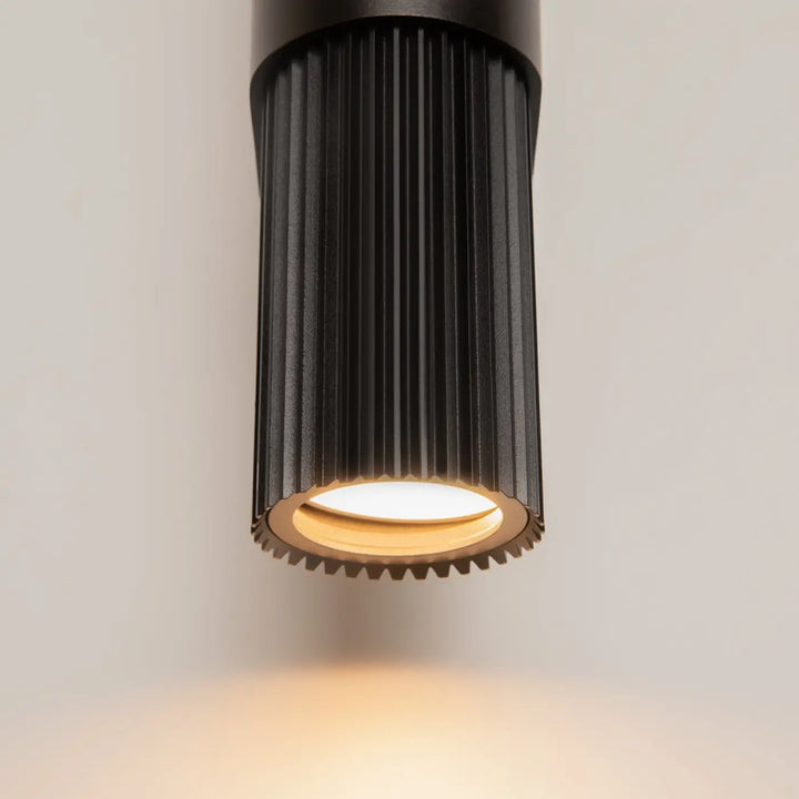 Applique murale dynamics cylindre strié noir avec lumière led chaude et rainures verticales pour éclairage intérieur