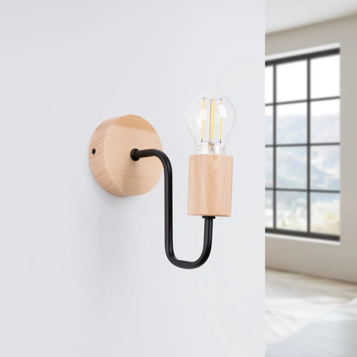 Applique murale timbo avec bras d’acier coudé noir et base en bois naturel tenant une ampoule à filament visible