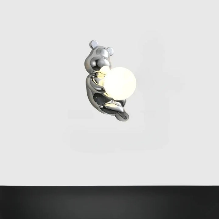 Applique murale teddy en chrome brillant en forme d’ours tenant une ampoule sphérique blanche design moderne