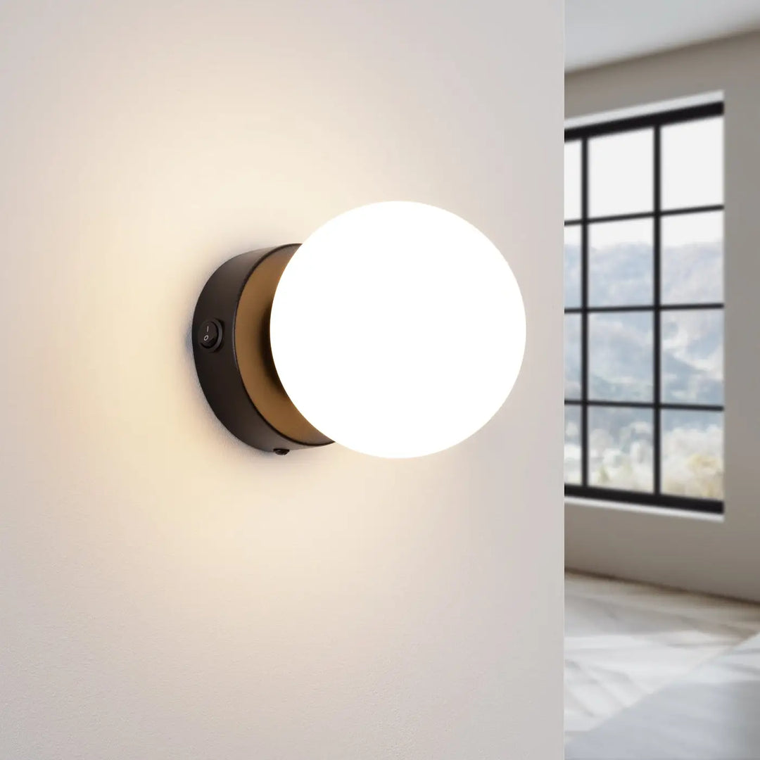 Applique yoli 1 noir avec base circulaire mate et abat-jour sphérique en verre dépoli design minimaliste cheminée yoli