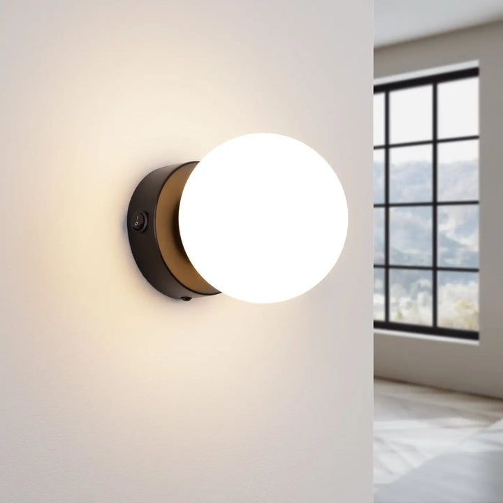 Applique yoli 1 noir avec base circulaire mate et abat-jour sphérique en verre dépoli design minimaliste cheminée yoli