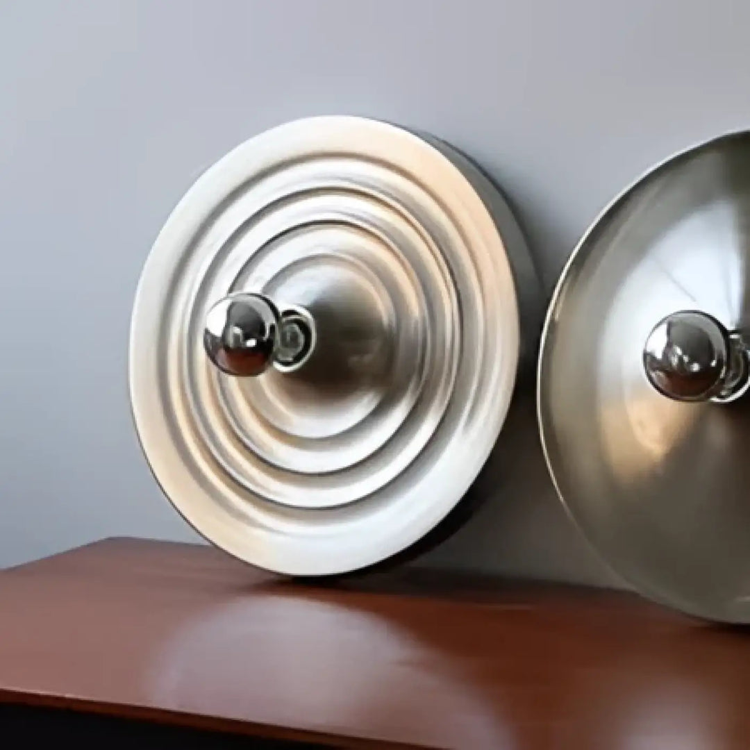 Deux capuchons métalliques circulaires avec rainures concentriques et boutons centraux pour applique murale industrielle diska