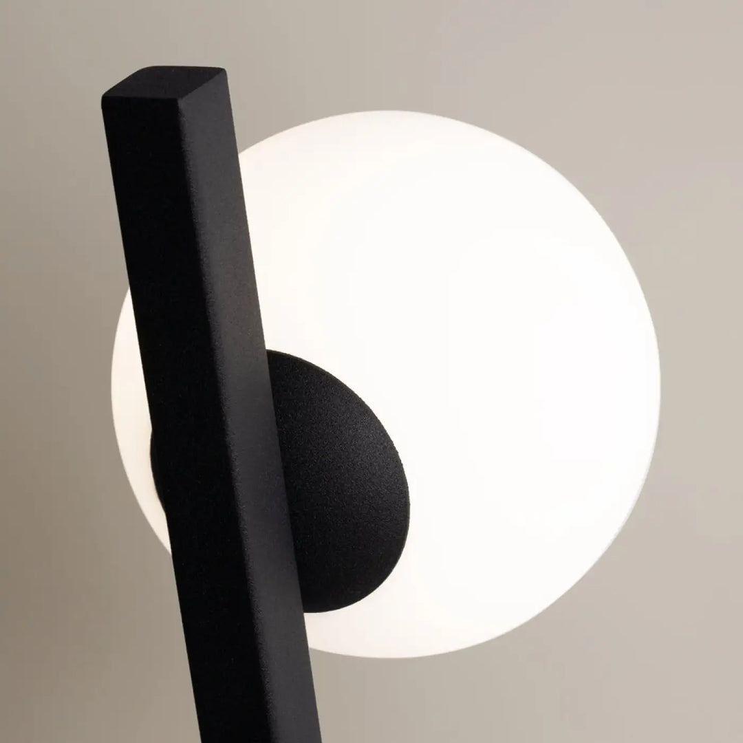Applique murale kazimir en métal noir avec plaque inclinée, lampe à tige rectangulaire mate et globe blanc lumineux