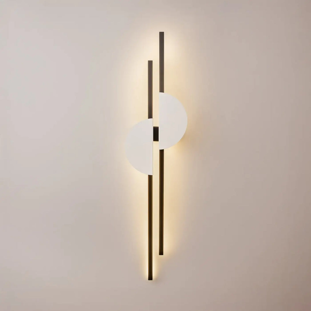 Applique murale led skyline avec deux tiges verticales noires et diffuseur circulaire blanc émettant une lumière chaude