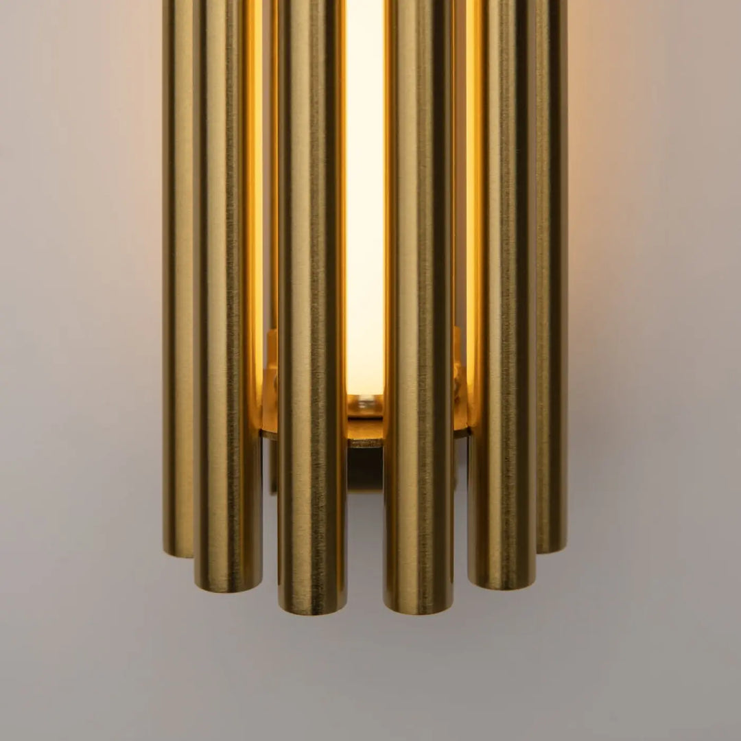 Applique murale led sonata cylindre en métal doré avec tubes verticaux éclairant une lumière chaude et diffuse