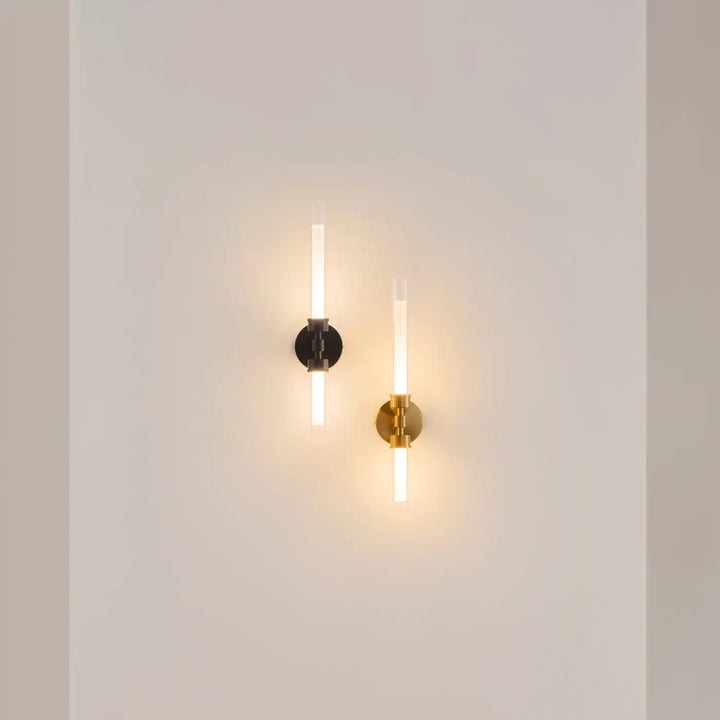 Deux appliques murales led minimalistes avec base noire et métal doré, tube long en verre diffusant une lumière chaude