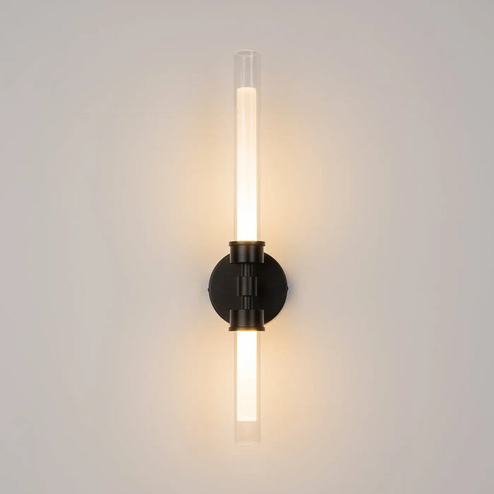Applique murale en métal noir moderne steLO avec deux tubes longs en verre émettant une lumière led chaleureuse