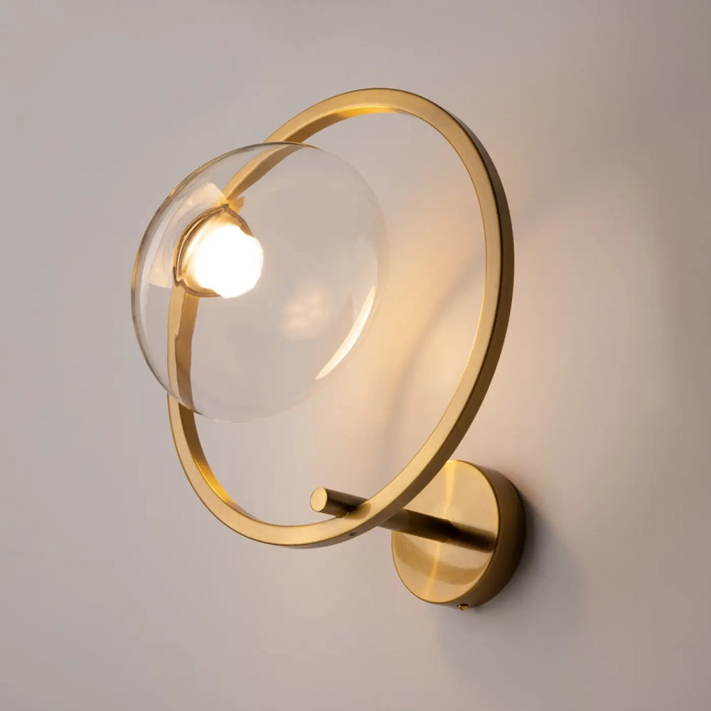 Applique murale lunare art déco en doré avec un globe en verre transparent et un anneau circulaire minimaliste