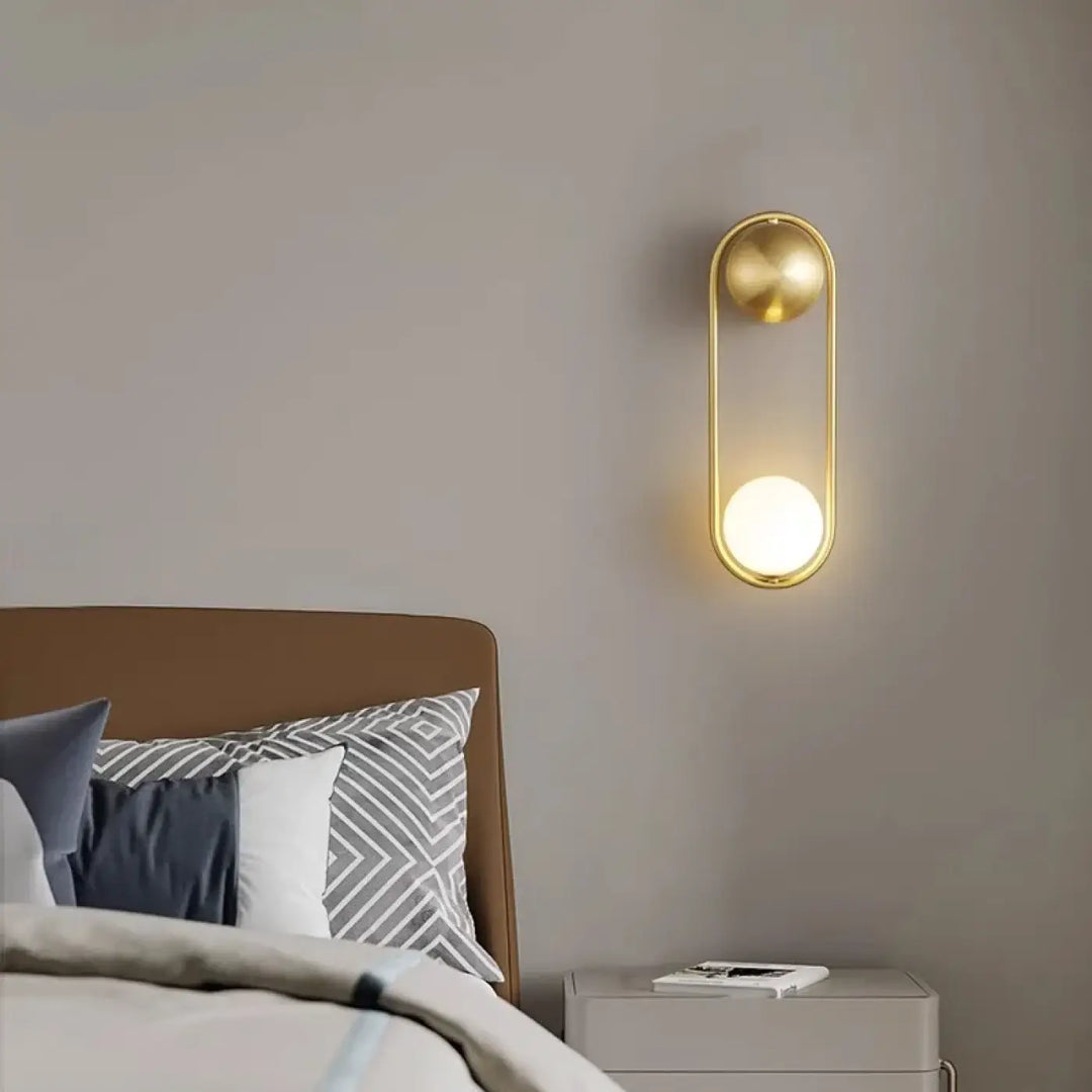 Applique murale isaih en métal doré avec cadre ovale et accents sphériques diffusant une lumière blanche élégante