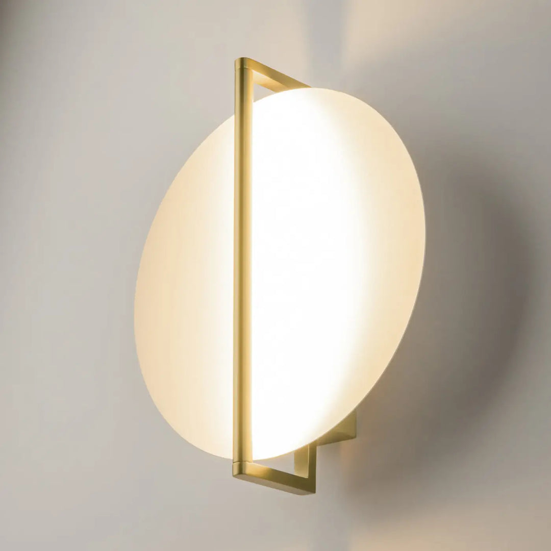 Applique murale mira en ton doré avec disque en verre opale givré et cadre metallique géométrique minimaliste