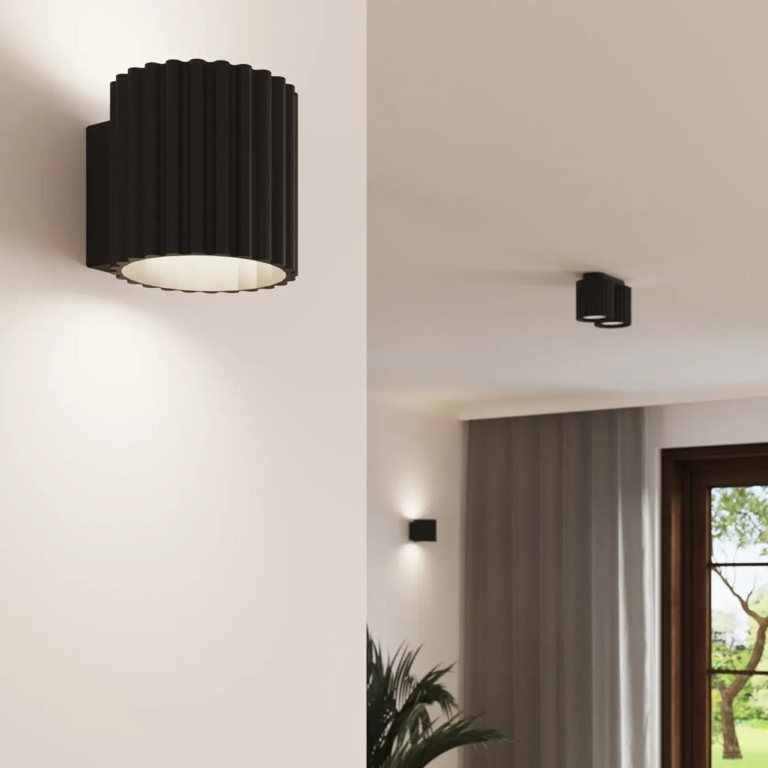 Applique murale aura noir en forme unique inspirée avec extérieur cannelé et lumière intérieure chaude circulaire