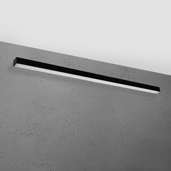 Applique murale pinne 150 noir led rectangulaire montée sur mur béton gris avec paramètres d’éclairage et différentes tailles
