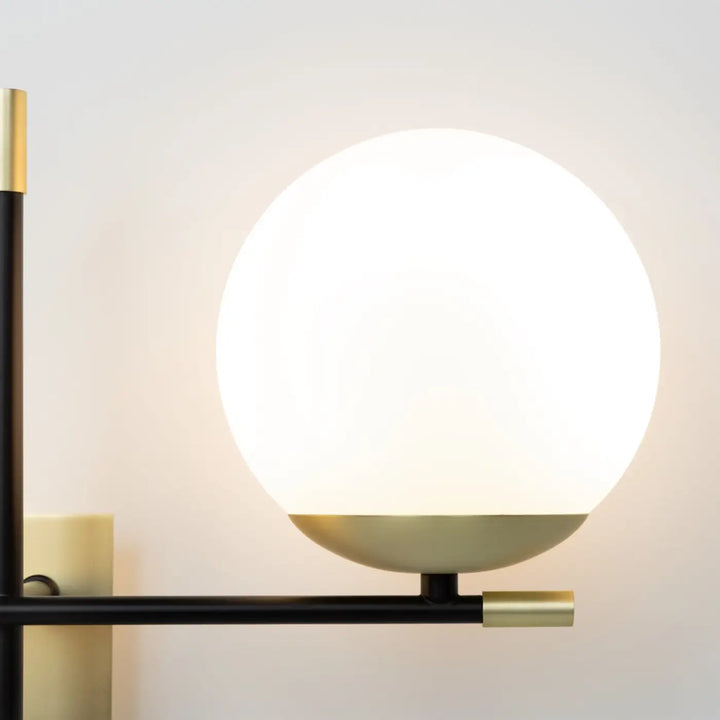 Applique murale nostalgie double globe en verre opalin avec structure en acier noir et accents dorés modernes