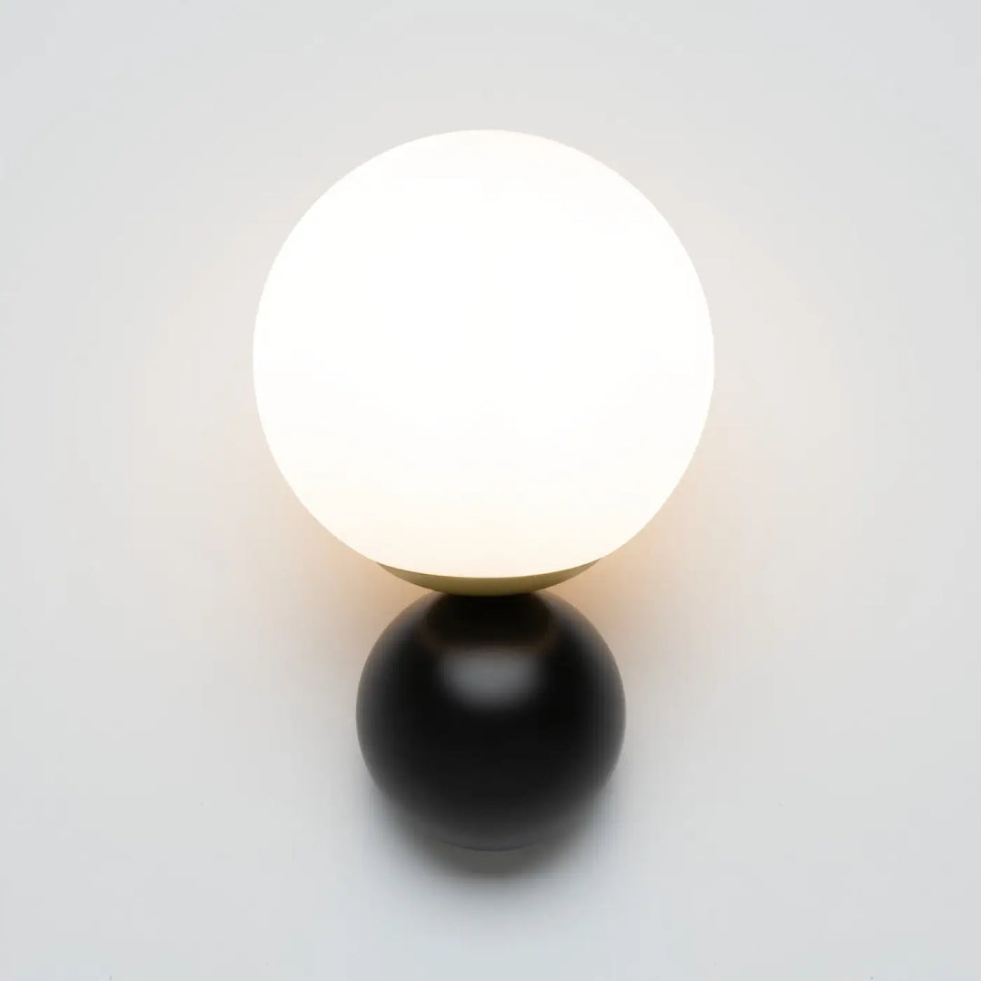 Applique murale nostalgia avec globe opalin lumineux sur base sphérique en acier noir mat minimaliste