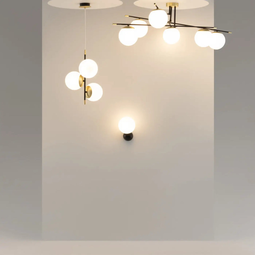 Applique murale nostalgia avec globe opalin en acier noir et finitions dorées pour un éclairage moderne minimaliste