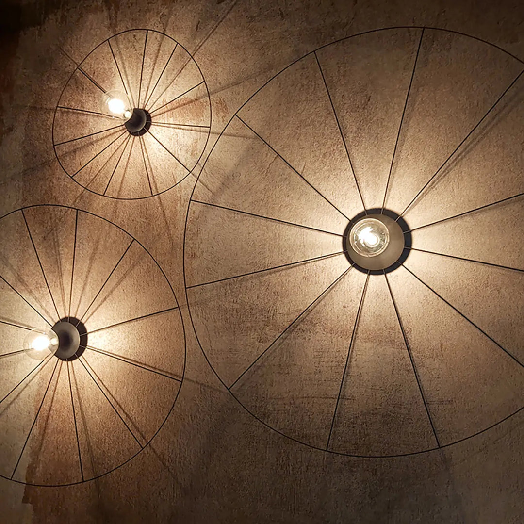 Trois lampes eskola circulaires en fil métallique noir au design rustique industriel de la collection eskola