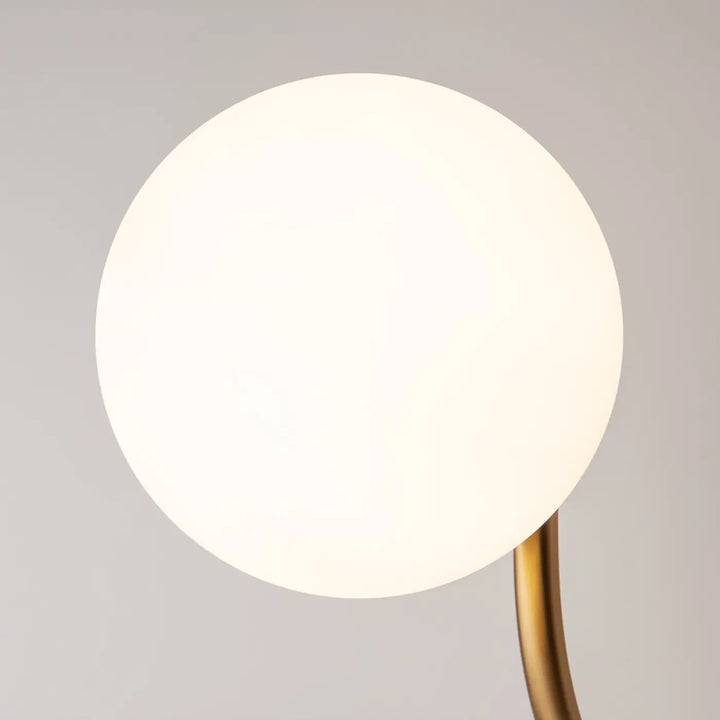 Applique murale rendez vous avec globe en verre dépoli blanc et bras doré en métal fin pour un éclairage minimaliste