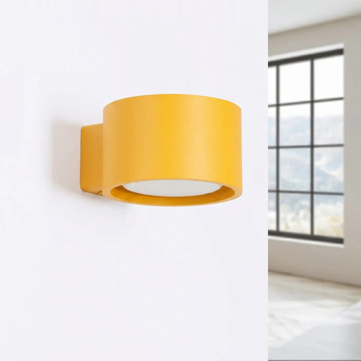 Applique murale ronde jaune éteinte, installée au mur