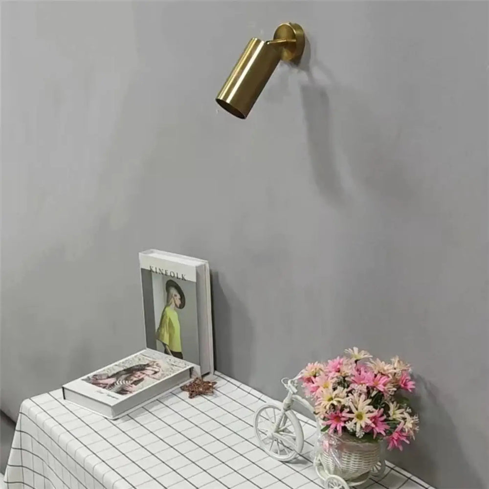 Applique murale cylia en métal doré de forme cylindrique avec un design moderne et épuré pour un éclairage ciblé