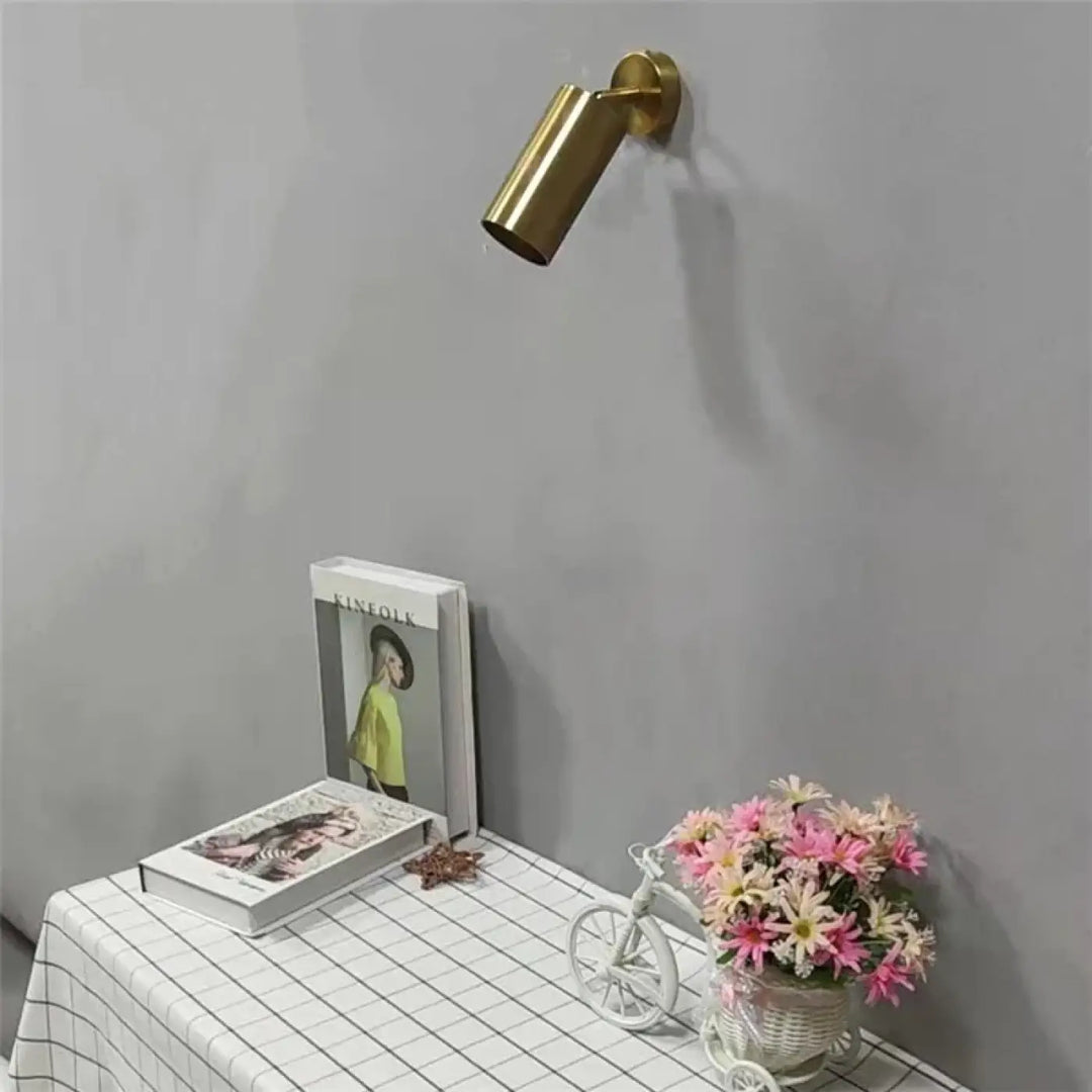 Applique murale cylia en métal doré de forme cylindrique avec un design moderne et épuré pour un éclairage ciblé